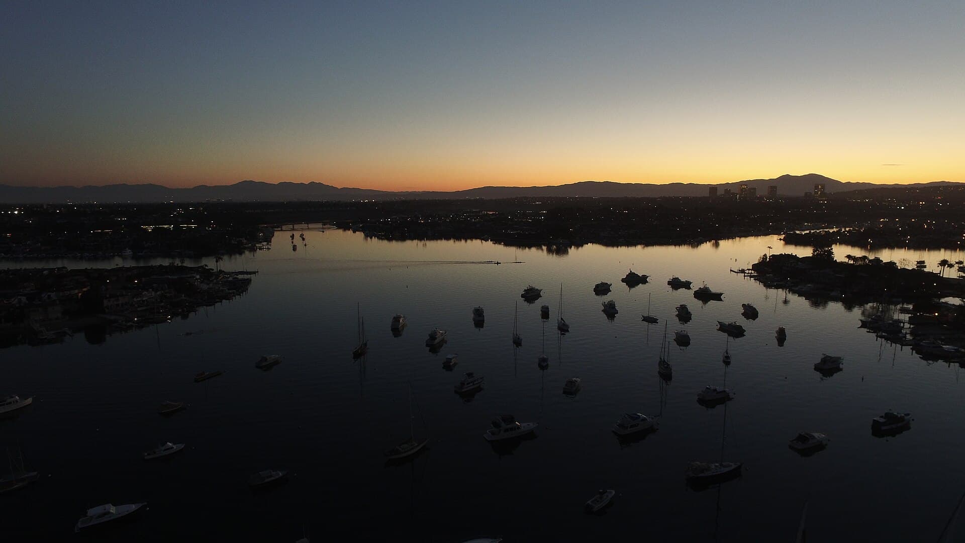 Newport Harbor at sunrise, bayfront estates along the water